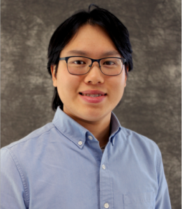 Jonathan Eng smiles. He has black hair and glasses, and he wears a blue button up.