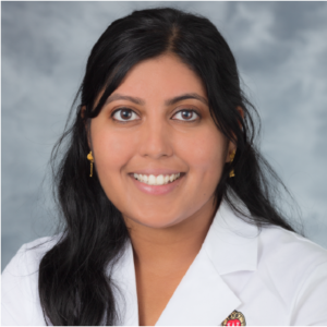 Headshot of woman with dark hair wearing a lab coat